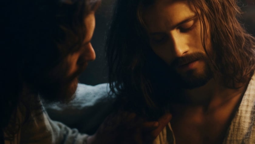 Dois homens de cabelo comprido e barba, um deles apoia a mão no ombro do outro.