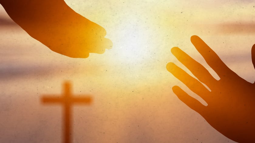 Duas mãos se estendem uma em direção à outra, com uma cruz ao fundo.