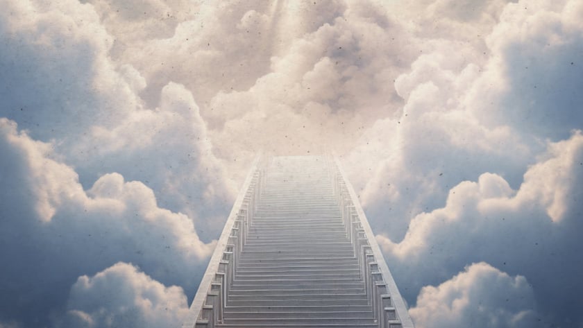 Longa escada de degraus cinzentos subindo entre nuvens grandes em direção a uma luz no céu.