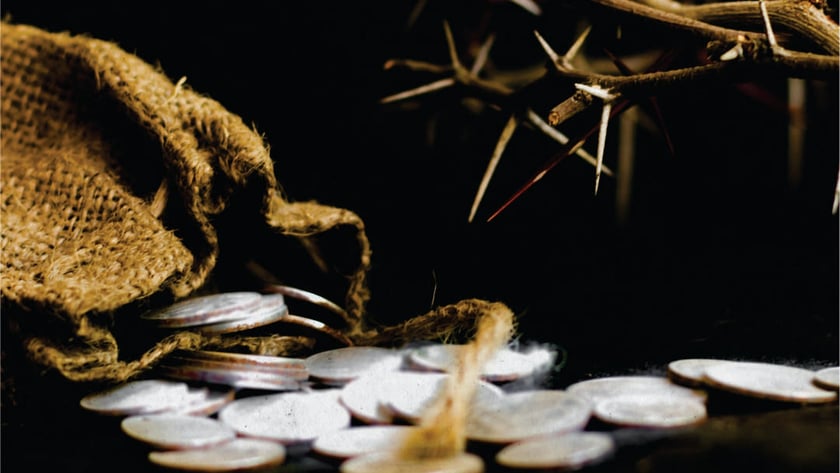 Moedas de prata espalhadas de um saco de juta, ao lado de uma coroa de espinhos.