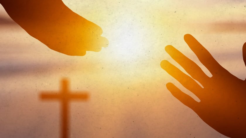 Duas mãos se estendem uma em direção à outra, com uma cruz ao fundo.