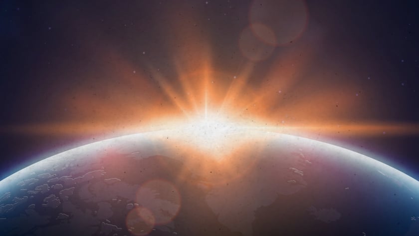 Sol surgindo atrás da curva de um planeta, com estrelas no céu escuro.