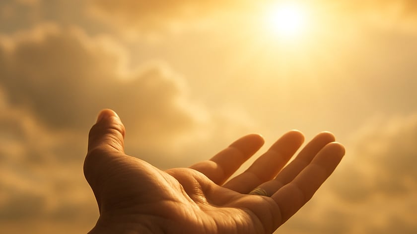 Mão aberta com a palma para cima, estendida em direção ao sol entre nuvens.
