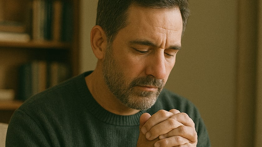Homem de barba com as mãos unidas sobre uma Bíblia, olhos fechados, em casa: "HOLY BIBLE"
