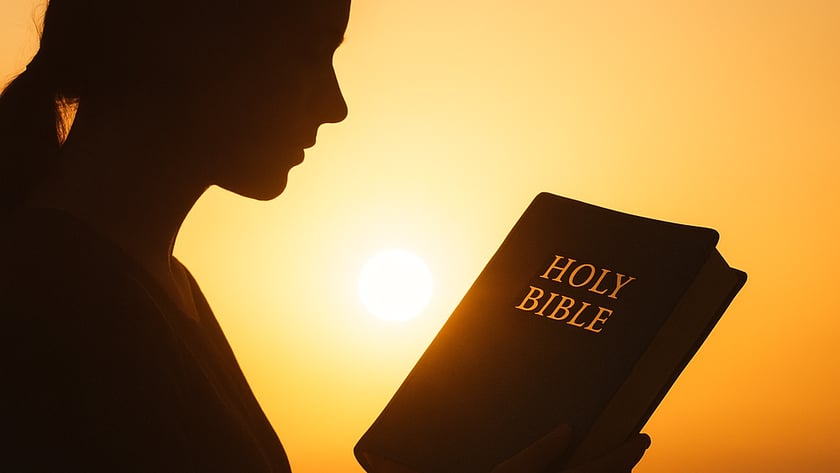 Silhueta de uma mulher lendo uma Bíblia ao pôr do sol: "HOLY BIBLE".