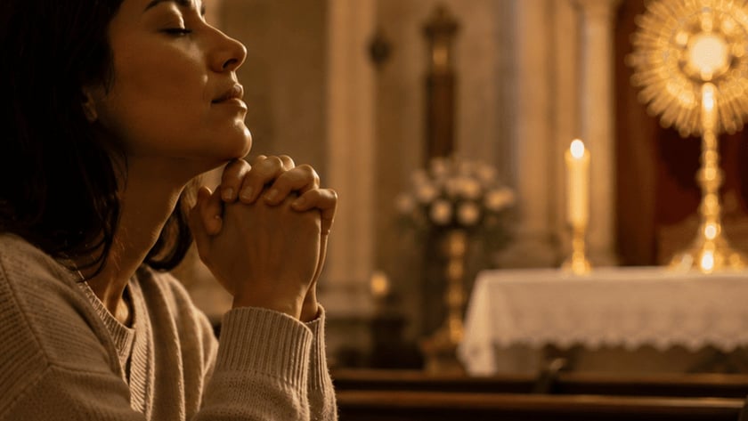 Mulher de olhos fechados e mãos postas reza num banco de igreja diante de um ostensório dourado.