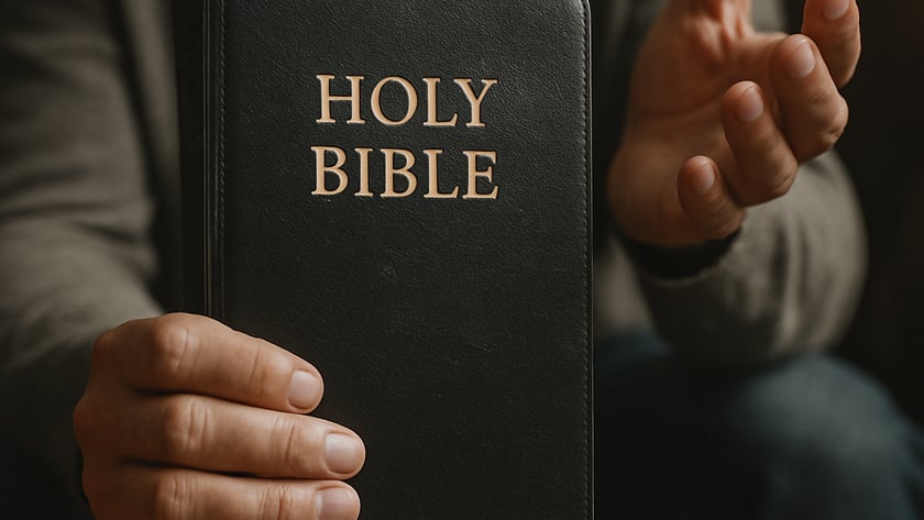 Homem de camiseta cinza segura uma Bíblia preta e gesticula com a outra mão: "HOLY BIBLE".