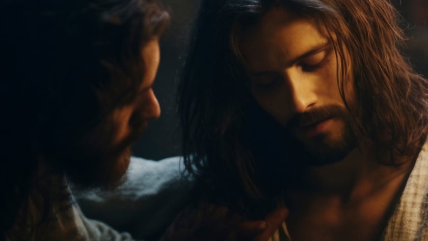 Dois homens de cabelo comprido e barba, um deles apoia a mão no ombro do outro.