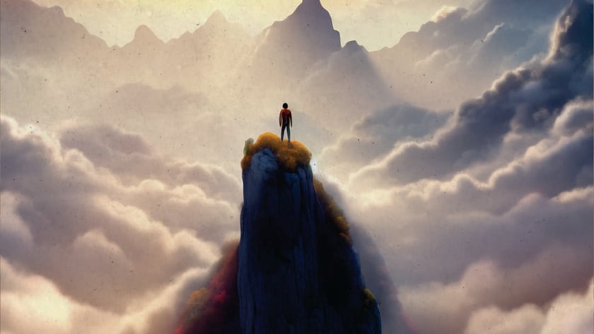 Pessoa de pé no topo de um pico rochoso, acima de nuvens e montanhas.