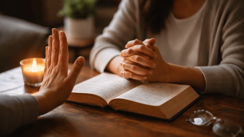 Uma mão espalmada recusa, enquanto outra pessoa de mãos unidas está diante de uma Bíblia aberta.