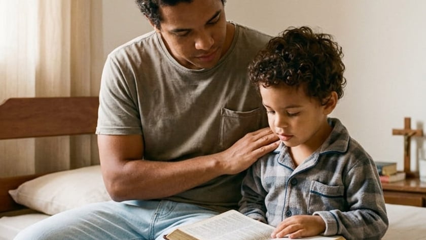 Homem e menino de pijama sentados numa cama, lendo juntos um livro grande aberto.