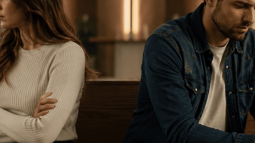 Mulher e homem sentados em um banco de igreja, de braços cruzados, olhando para lados opostos.